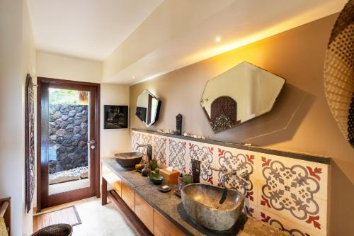 a bathroom with two sinks on the wall at Villa Palem in Tabanan