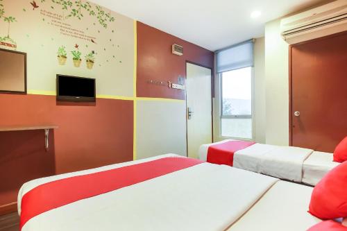 a hotel room with two beds and a tv at Hotel O Taj (seksyen 7) in Shah Alam