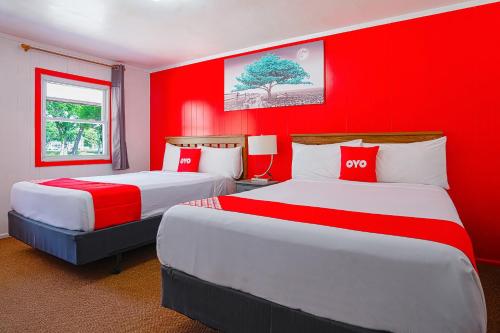 two beds in a room with red walls at OYO Hotel Lamberton Hwy 14 in Lamberton
