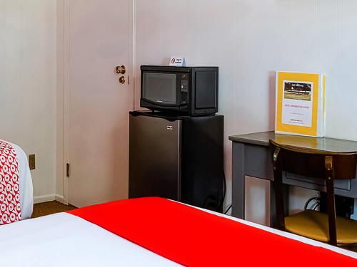 a room with a bed and a tv on a refrigerator at OYO Hotel Lamberton Hwy 14 in Lamberton