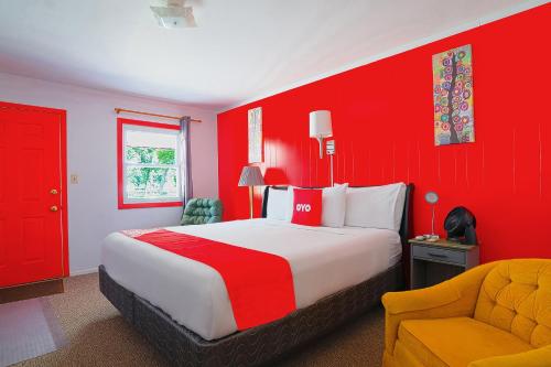 a red bedroom with a bed and a chair at OYO Hotel Lamberton Hwy 14 in Lamberton