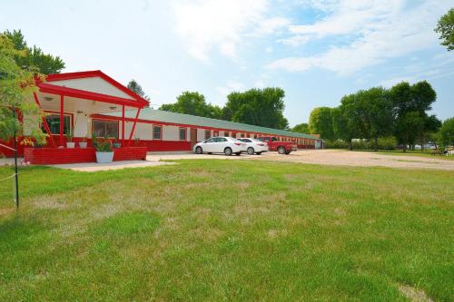 a red building with two cars parked in a parking lot at OYO Hotel Lamberton Hwy 14 in Lamberton