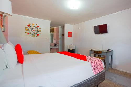 a bedroom with a large white bed with red accents at OYO Hotel Lamberton Hwy 14 in Lamberton