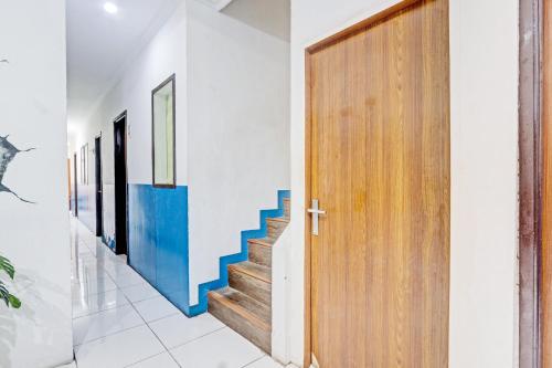 un corridoio con porta in legno e scale di Hotel O Near Mall Ciputra 2 a Semarang