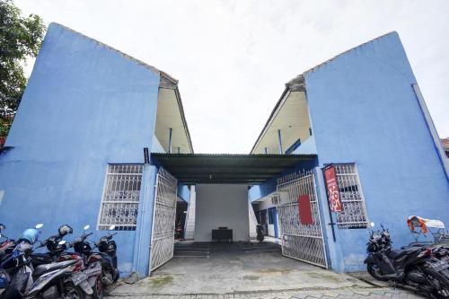 a group of motorcycles parked in front of a blue building at OYO Life 90523 Homestay Jenggolo in Sidoarjo
