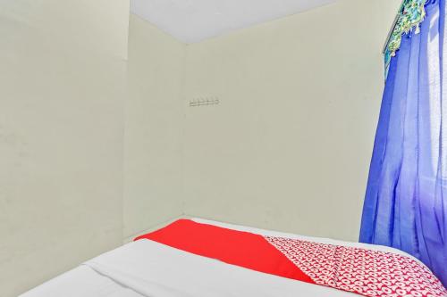 a room with a red and blue curtain and a bed at OYO Life 90523 Homestay Jenggolo in Sidoarjo