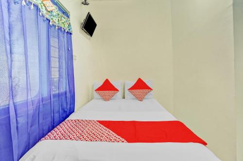 a bed with two pillows on it in a room at OYO Life 90523 Homestay Jenggolo in Sidoarjo