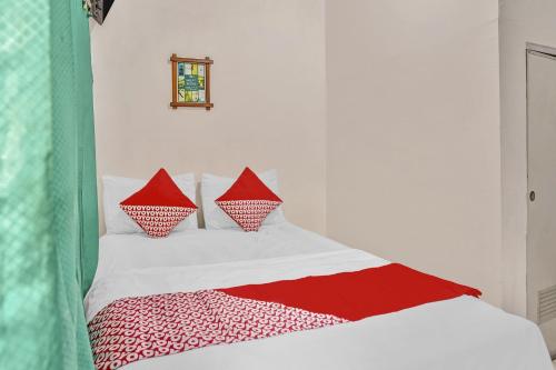 a bed with red and white pillows on it at OYO Life 90523 Homestay Jenggolo in Sidoarjo