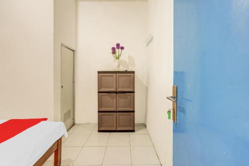 a room with a cabinet with a vase of flowers on it at OYO Life 90523 Homestay Jenggolo in Sidoarjo