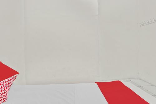 a white room with a red object on the floor at OYO Life 90523 Homestay Jenggolo in Sidoarjo