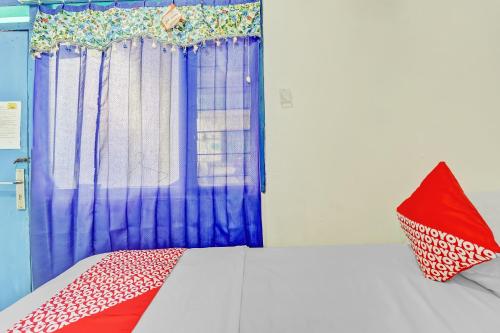 a bedroom with a bed with a blue curtain at OYO Life 90523 Homestay Jenggolo in Sidoarjo