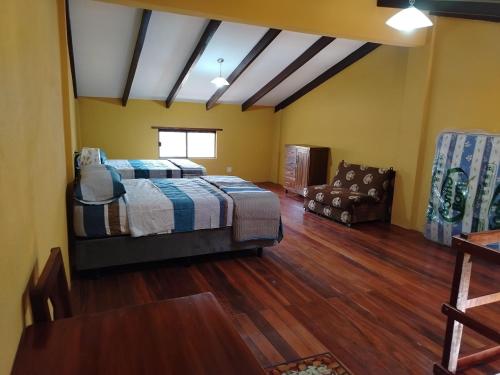 a large bedroom with a bed and a couch at Cabaña J y M in Samaipata
