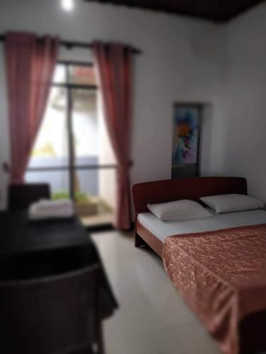 a bedroom with two beds and a window at Family Bricks Bungalow in Ratnapura