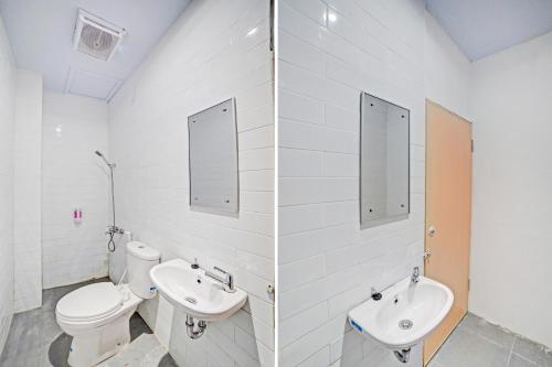 a bathroom with two sinks and a toilet at Hotel O Gamacity Residence in Pulauberayan Dadap