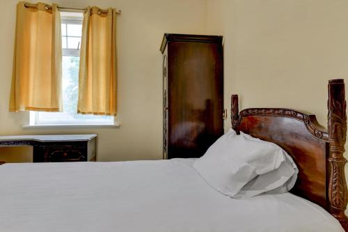 a bedroom with a bed with a wooden headboard and a window at Empire Hotel in Leicester
