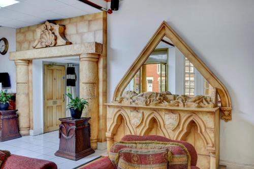 a large mirror in a room with a bed at Empire Hotel in Leicester