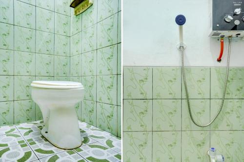 a bathroom with a toilet and a shower at Hotel O Wisma Al-fahmi Syariah in Maniskaler