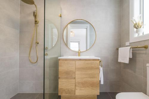 un bagno con lavandino e specchio di East Belmont, 38 Tomaree Rd - spa, linen, Wi-Fi, Air Con , Games Room a Shoal Bay