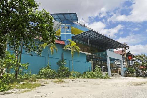 a blue building with a sign on the side of it at Hotel O Papi Inn Guesthouse in Palangkaraya