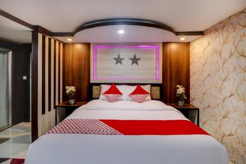 a bedroom with a large white bed with red pillows at Collection O 90564 Hotel Merangin Syariah in Bangko