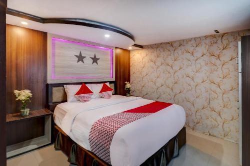 a bedroom with a large bed with red pillows at Collection O 90564 Hotel Merangin Syariah in Bangko