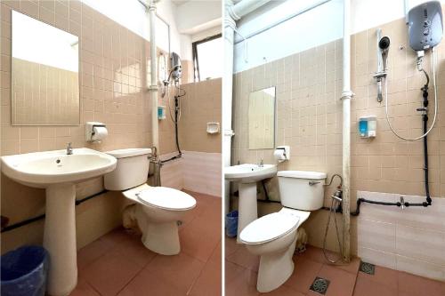 a bathroom with two toilets and a sink at Hotel O Wg Guest House in George Town