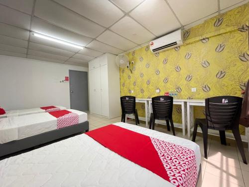 a hotel room with two beds and a bar with chairs at Hotel O Wg Guest House in George Town