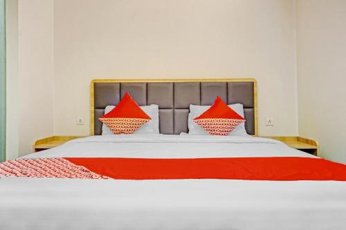 a bedroom with a bed with red pillows on it at Capital O 90635 Tango Juliet Residence in Jakarta
