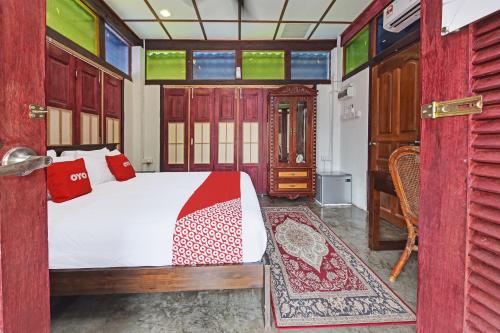 a bedroom with a white bed and red pillows at Hotel O Jentayu Homestay Pontian in Pontian Kecil