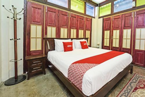 a bedroom with a large bed with red pillows at Hotel O Jentayu Homestay Pontian in Pontian Kecil