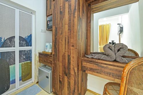 a room with a wooden wall and a mirror at Hotel O Jentayu Homestay Pontian in Pontian Kecil