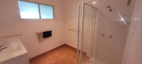 a bathroom with a shower and a sink at Cabbage Palm Holiday Home in Agnes Water