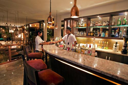 two men standing at a bar in a restaurant at Gending Kedis Luxury Villas & Spa Estate in Jimbaran