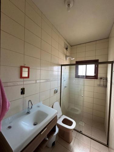 a bathroom with a sink and a toilet and a shower at Pousada barcelos in Florianópolis