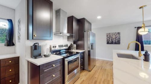 a kitchen with wooden cabinets and a stove top oven at Spacious Family Retreat in Denver in Denver
