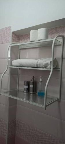 a shelf in a bathroom with towels and a bottle at The Coffee Residences at KINGS MILLENNIUM APARTMENTS, near JKI Airport 3 Bedroom in Nairobi