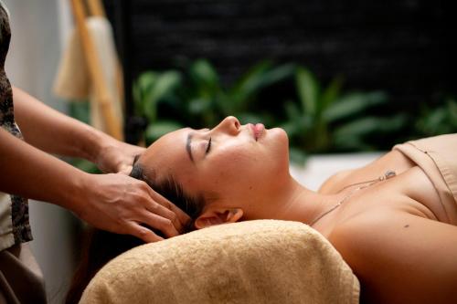 a woman getting her hair cut by a therapist at Gending Kedis Luxury Villas & Spa Estate in Jimbaran