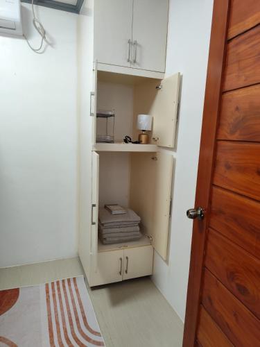 a room with a closet with white cabinets and a door at Drop by Playa Nature Hotel in Morong