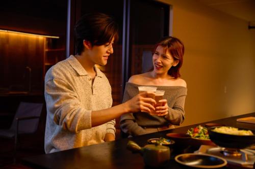 two women standing next to a table with food at No-12 Kasima Fan Zone in Kashima