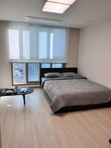 een slaapkamer met een groot bed en een tafel bij DDMOP-Seoul in Seoul