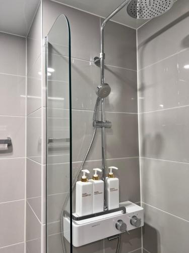 een badkamer met een douche en 4 flessen op een plank bij DDMOP-Seoul in Seoul