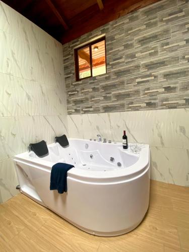 a white bath tub in a bathroom with a window at The Lookout Hideaway in Baños