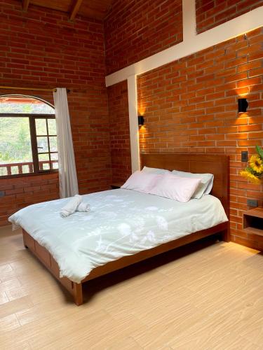 a bed in a room with a brick wall at The Lookout Hideaway in Baños