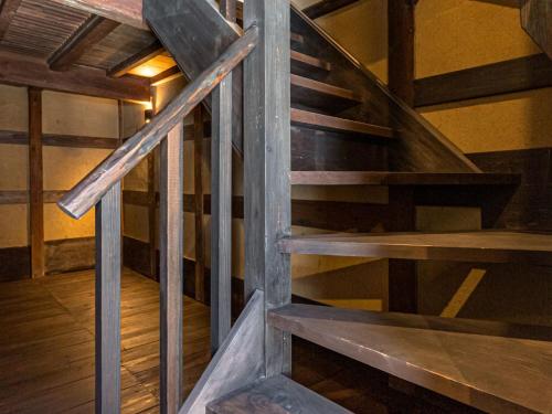 a wooden spiral staircase in a room with wooden floors at NIPPONIA Sado 佐渡相川 金山町 in Sado