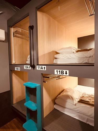 a room with two bunk beds and a blue stool at Mikami Asakusabashi Hotel in Tokyo