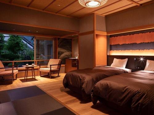 a bedroom with two beds and a balcony at Shima Tamura in Nakanojo