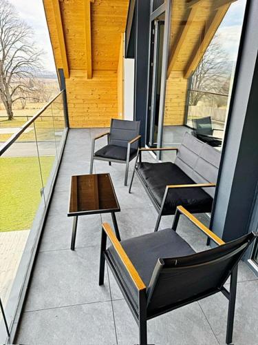 a balcony with chairs and a table on a building at Apartmán Nad Údolím Šumava in Prachatice