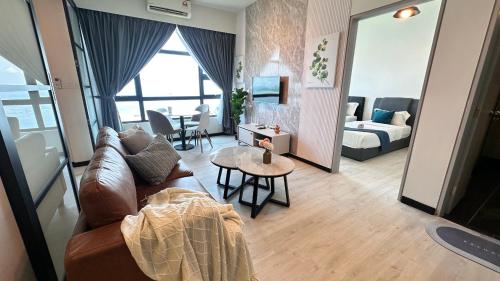 a living room with a couch and a table at JQ1 SEA & POOL or CITY View WIFI I WASHING MACHINE for Some Units I CUCKOO WATER Jesselton Quay by R2 in Kota Kinabalu