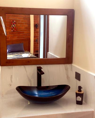 a bathroom with a sink in front of a mirror at The Lookout Hideaway in Baños