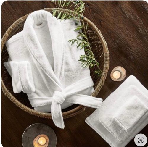 a basket with white towels and candles on a table at Klein-Hangklip Remote Mountain Studio Cottage in Rooiels